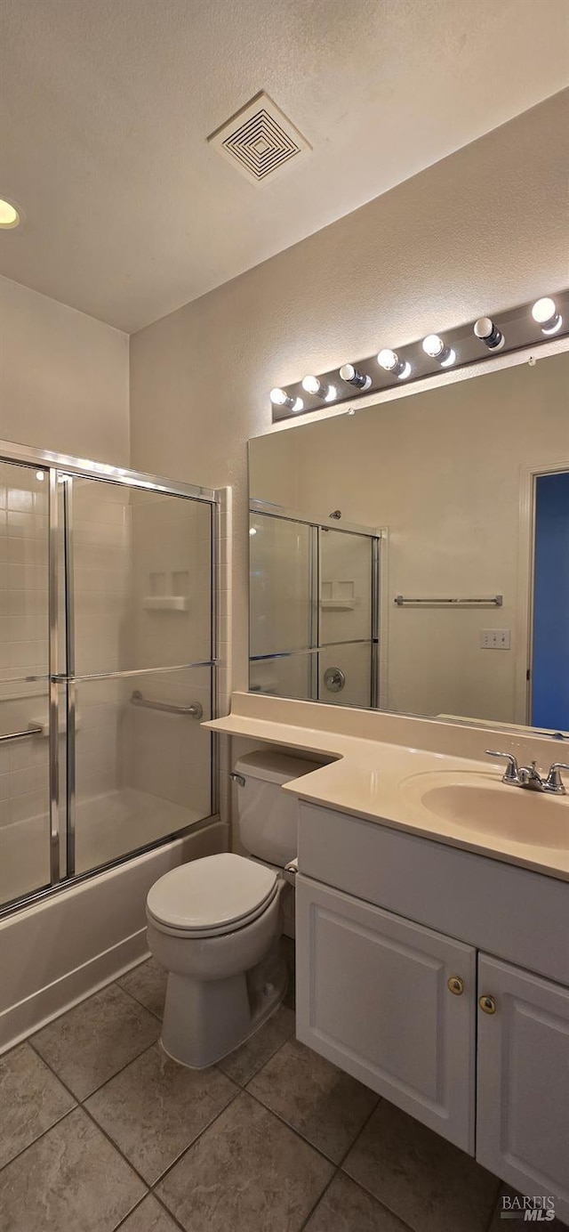 full bathroom with tile patterned floors, vanity, toilet, and combined bath / shower with glass door