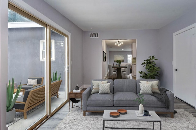 living area with light wood-style floors, baseboards, and visible vents