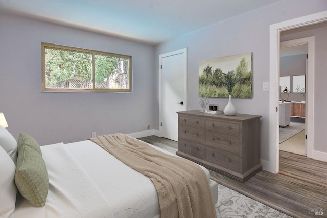 bedroom featuring wood finished floors and baseboards