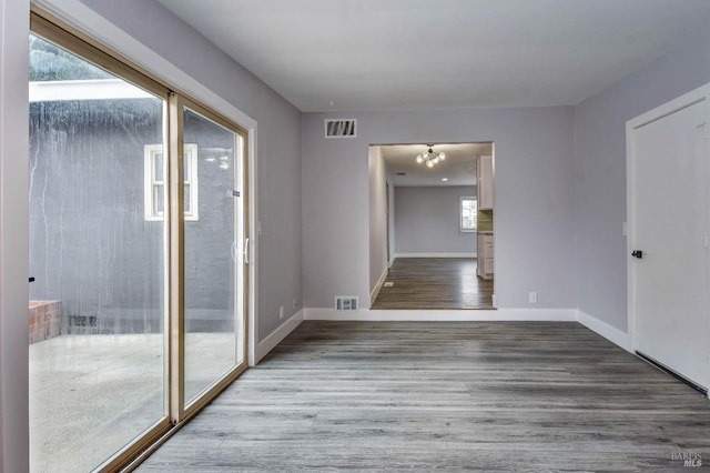 empty room featuring baseboards, visible vents, and wood finished floors