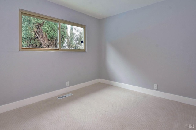 carpeted empty room with visible vents and baseboards