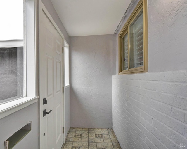 entryway with stone finish flooring and a textured wall