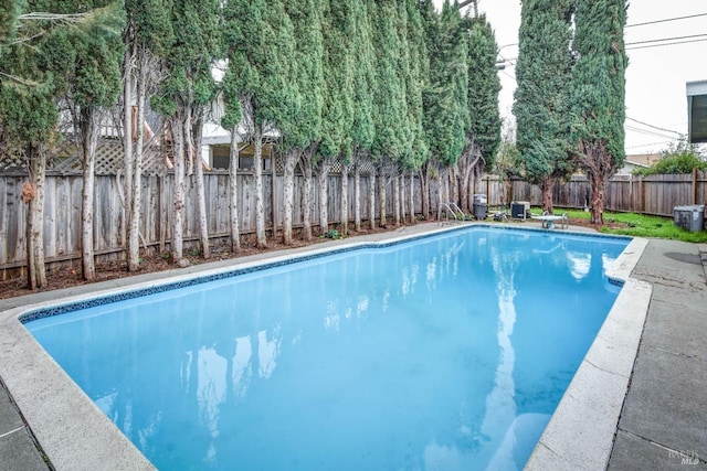 view of swimming pool featuring a diving board, a fenced backyard, and a fenced in pool