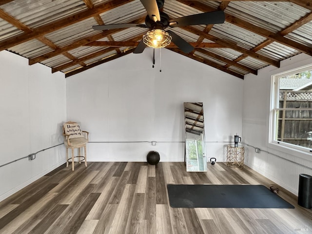 exercise area featuring ceiling fan, wood-type flooring, and lofted ceiling