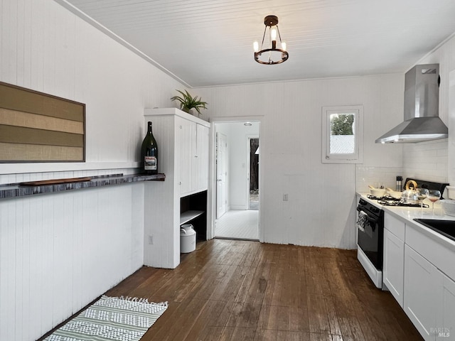 kitchen with white cabinets, hanging light fixtures, wall chimney exhaust hood, dark hardwood / wood-style floors, and white range with gas cooktop