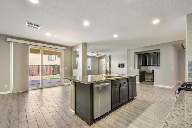 kitchen with stove, stainless steel dishwasher, ceiling fan, a kitchen island with sink, and sink