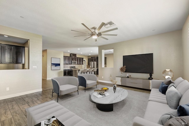 living room with ceiling fan and wood-type flooring