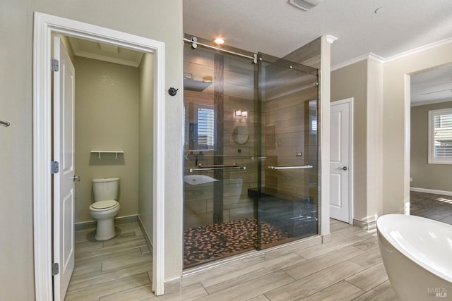 bathroom with a textured ceiling, toilet, crown molding, and plus walk in shower