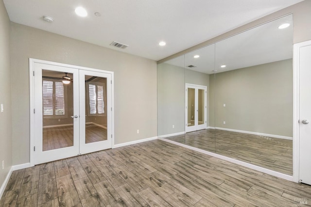 unfurnished room with hardwood / wood-style flooring and french doors