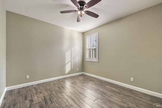 empty room with dark hardwood / wood-style flooring and ceiling fan