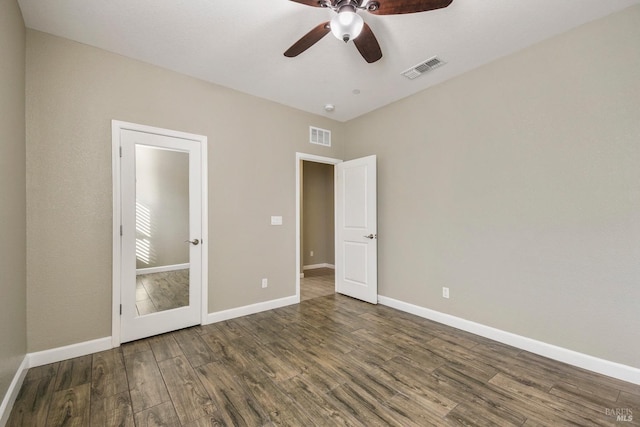 unfurnished bedroom featuring ceiling fan and dark hardwood / wood-style flooring