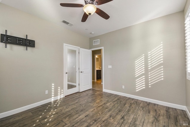 unfurnished bedroom featuring ceiling fan and dark wood-type flooring