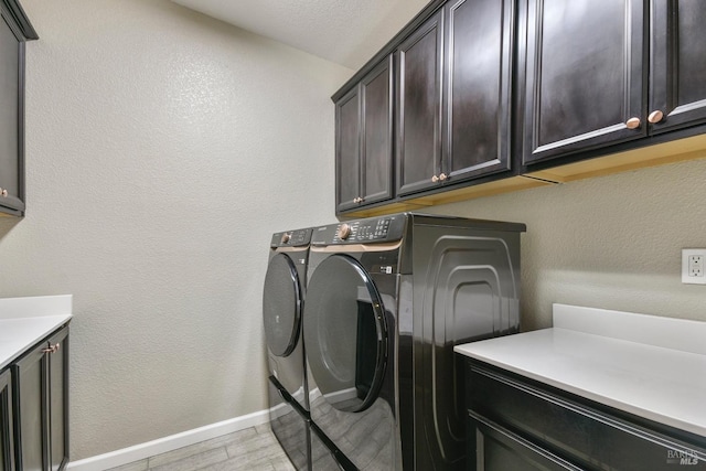 washroom featuring washing machine and dryer and cabinets