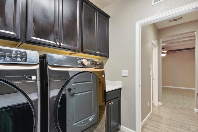 laundry area featuring cabinets, light hardwood / wood-style floors, washer and clothes dryer, and ceiling fan