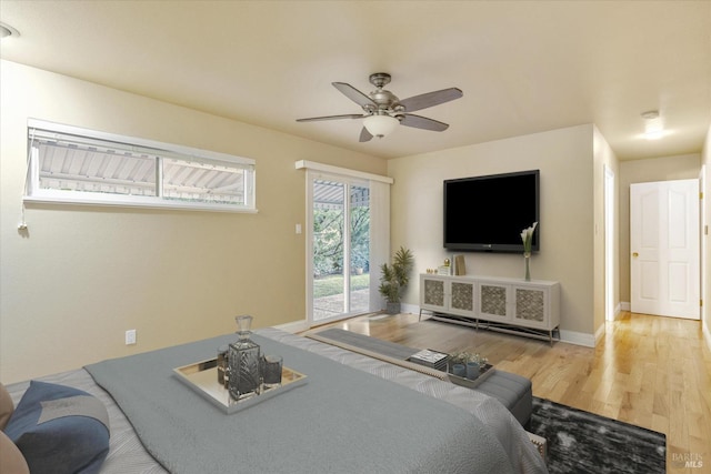 bedroom with access to exterior, hardwood / wood-style flooring, and ceiling fan