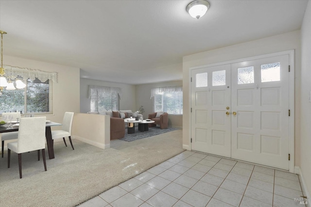 carpeted entrance foyer featuring a chandelier