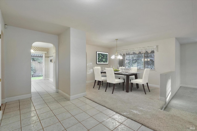 carpeted dining room with a wealth of natural light and a chandelier