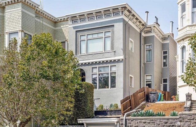 view of front of home featuring fence and stucco siding