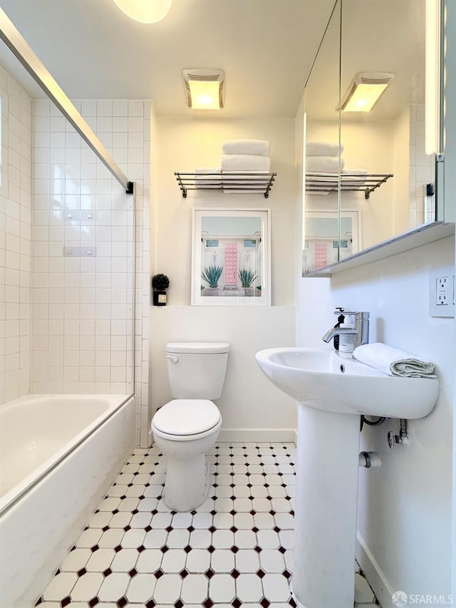 full bathroom featuring toilet, washtub / shower combination, and baseboards