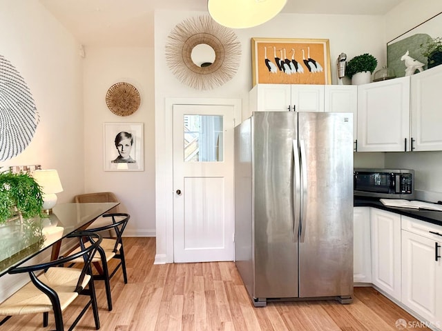 kitchen with appliances with stainless steel finishes, dark countertops, and white cabinets