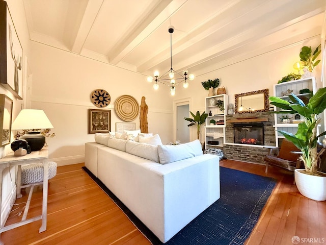 living area featuring a brick fireplace, beam ceiling, wood finished floors, and an inviting chandelier