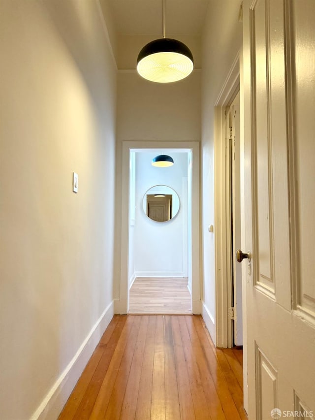 hall featuring light wood finished floors and baseboards