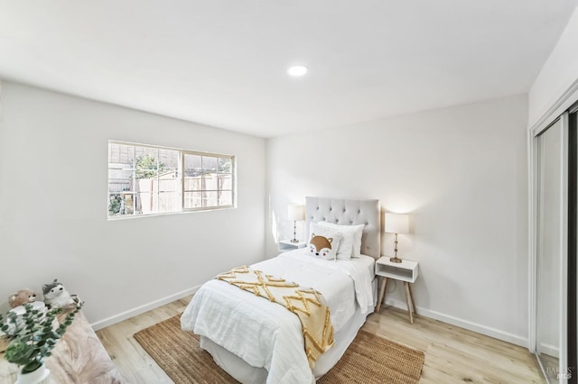 bedroom with light hardwood / wood-style flooring and a closet