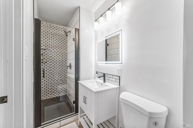 bathroom with vanity, an enclosed shower, and toilet