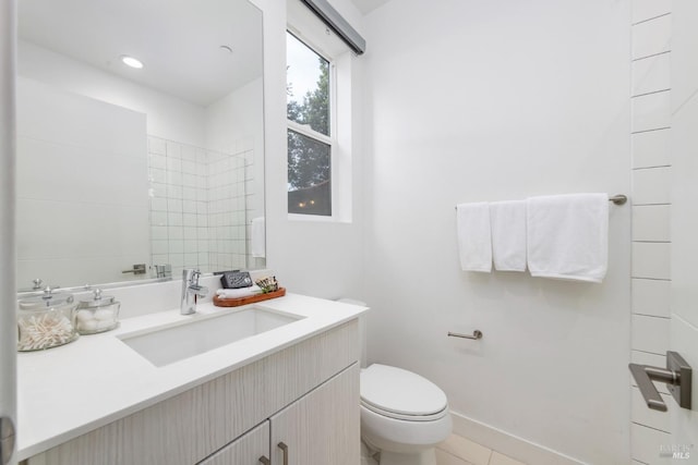 bathroom featuring tile patterned floors, vanity, toilet, and tiled shower