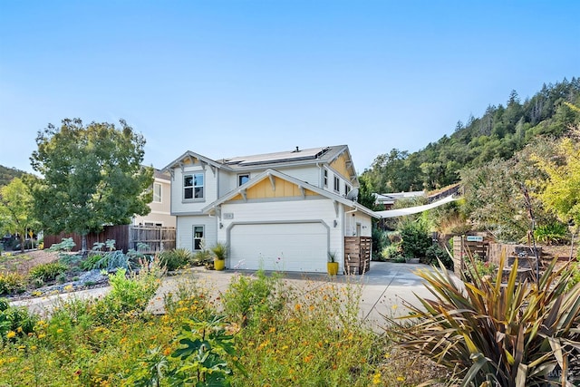 view of front of property featuring solar panels and a garage