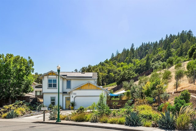 view of front of property with a garage and solar panels