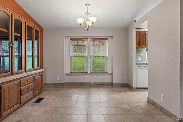 unfurnished dining area with a chandelier