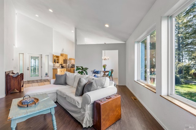 living room featuring lofted ceiling, dark wood-type flooring, and a chandelier