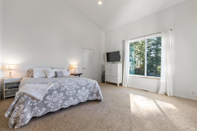 carpeted bedroom featuring high vaulted ceiling