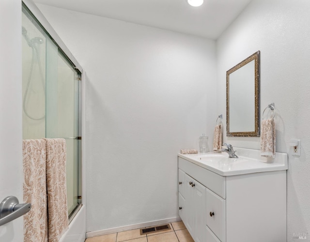 bathroom with tile patterned flooring, vanity, and shower / bath combination with glass door