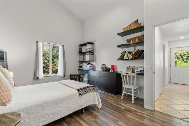 bedroom with high vaulted ceiling and hardwood / wood-style flooring