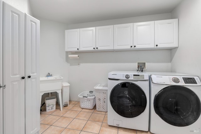 laundry room with cabinets, independent washer and dryer, and light tile patterned flooring