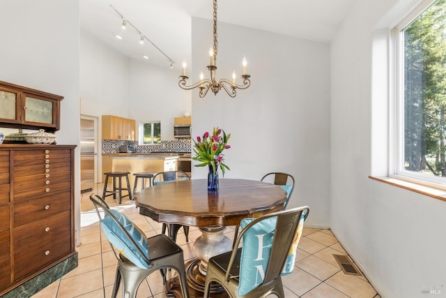 tiled dining area featuring a notable chandelier and a wealth of natural light