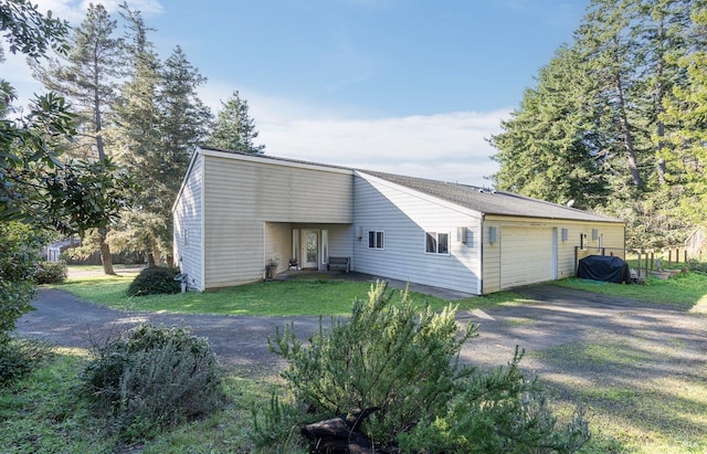 rear view of house with a yard and a garage