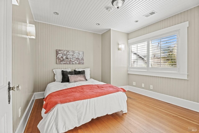 bedroom featuring visible vents, baseboards, and hardwood / wood-style floors