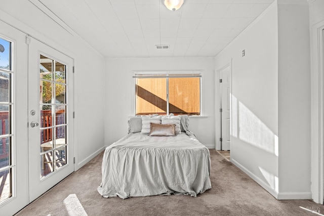 carpeted bedroom with visible vents, baseboards, and crown molding