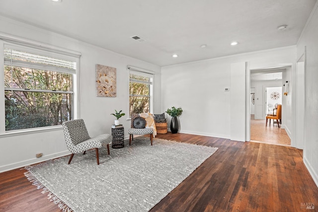 sitting room with visible vents, crown molding, baseboards, and wood finished floors