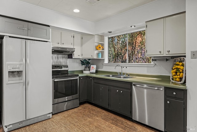 kitchen with stainless steel appliances, gray cabinetry, under cabinet range hood, open shelves, and a sink