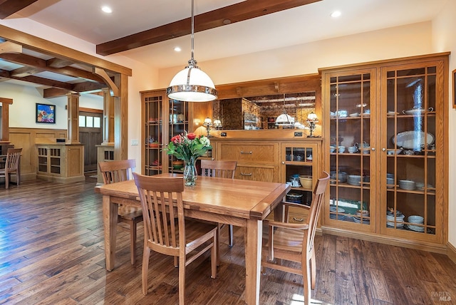 dining room featuring beam ceiling, dark hardwood / wood-style flooring, and ornate columns