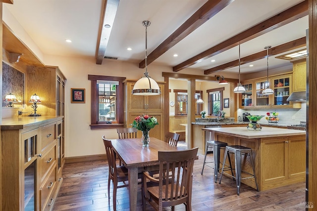 dining space featuring beam ceiling and dark wood-type flooring