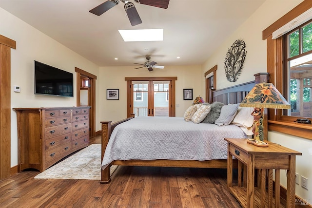 bedroom featuring hardwood / wood-style flooring, ceiling fan, and a skylight