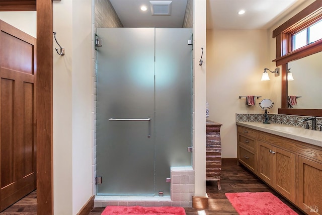 bathroom with hardwood / wood-style floors, vanity, and walk in shower