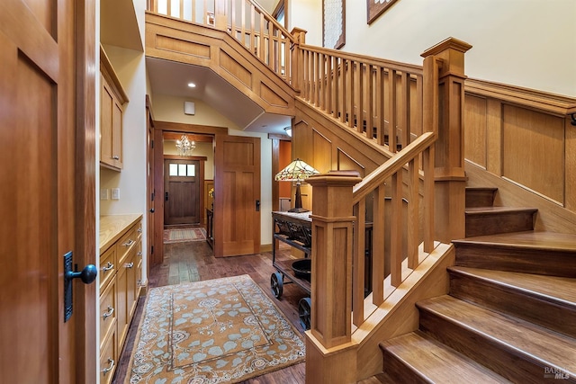 entryway featuring a towering ceiling and dark wood-type flooring