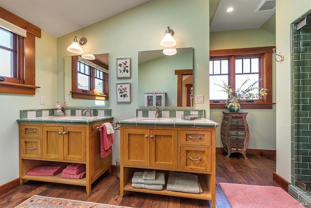 bathroom with plenty of natural light, vanity, hardwood / wood-style floors, and vaulted ceiling