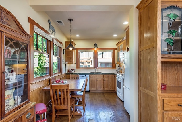 kitchen featuring decorative backsplash, dark hardwood / wood-style flooring, white appliances, sink, and pendant lighting